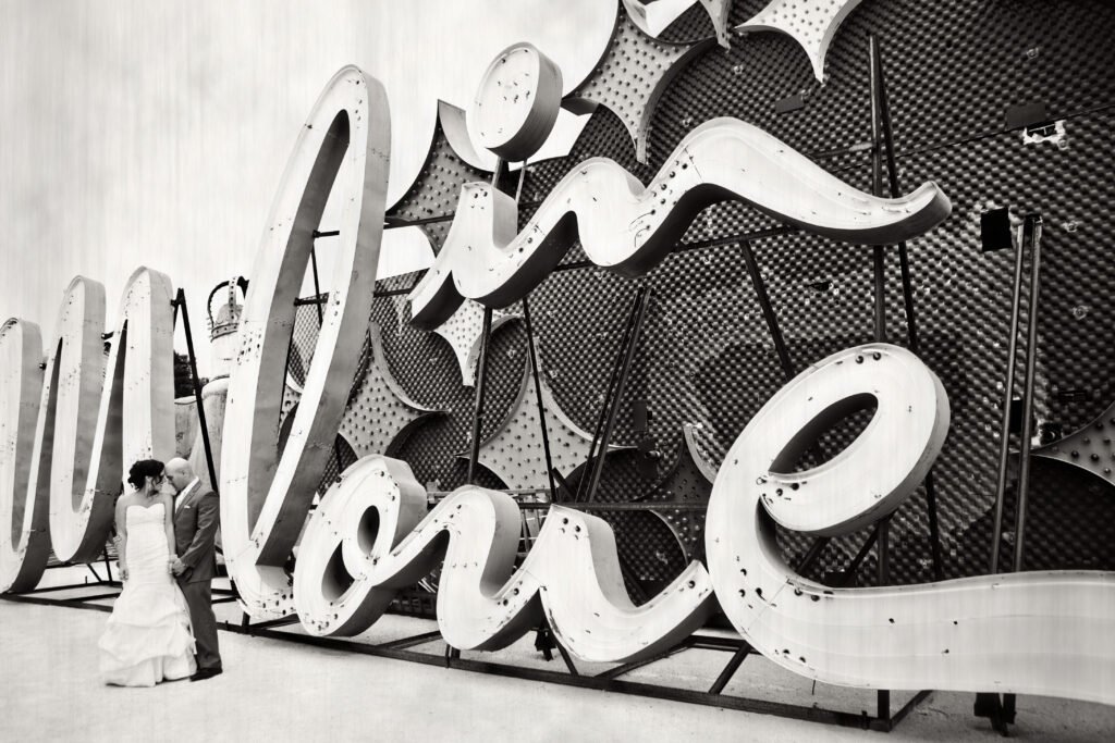 A bride and groom celebrate their wedding during a post-ceremony photo shoot at the Neon Boneyard Museum in Las Vegas