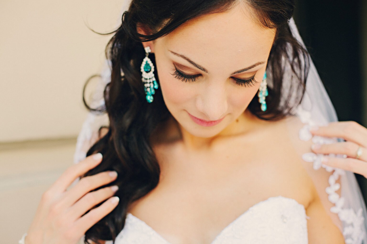 A beautiful bride admires her wedding dress and custom turquoise jewelry as she prepares for her wedding day