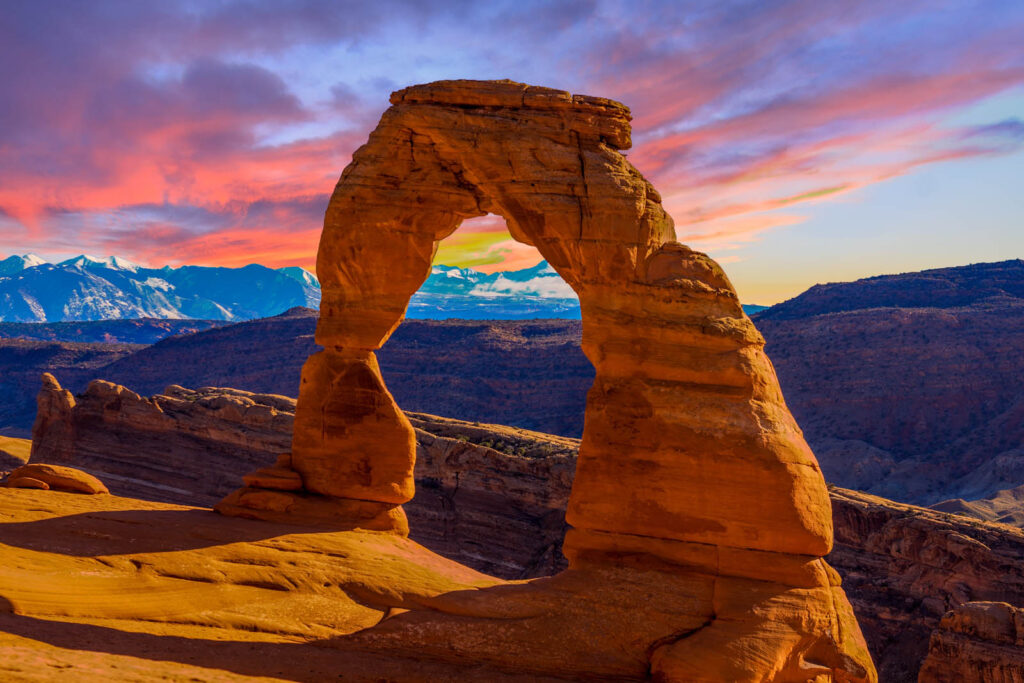 The iconic Delicate Arch in Arches National Park frames a stunning desert landscape, perfect for a memorable Utah elopement ceremony.